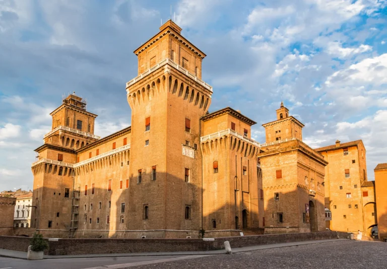 Il Castello Estense di Ferrara con le torri di mattoni rossi alla luce del tramonto