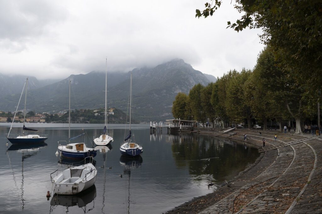 Lago di Como, barche a vela davanti al lungolago e le montagne