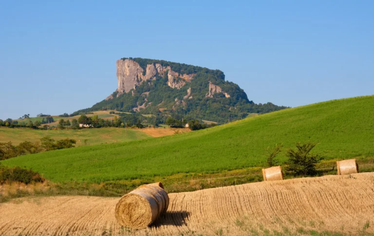 La Pietra di Bismantova sopra i campi di grano con le balle di fieno