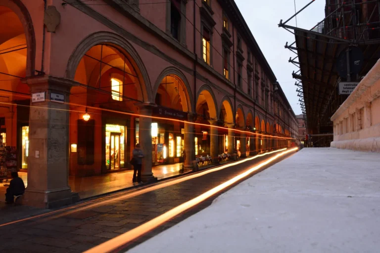 Un lungo portico nel centro di Bologna con le arcate illuminate